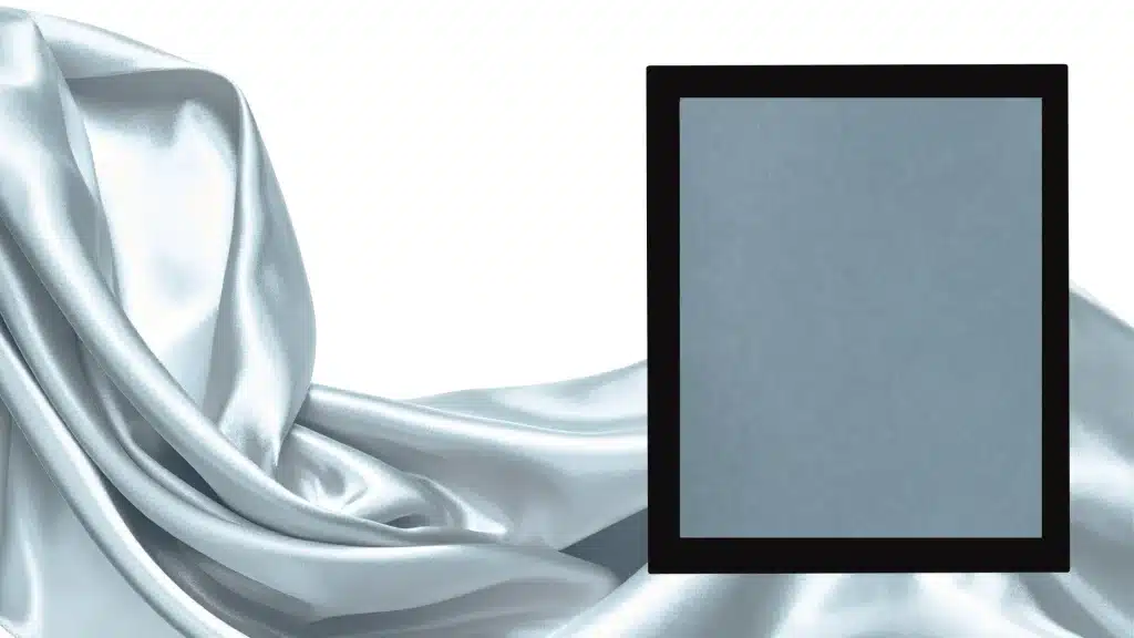 Charcoal grey sample in black frame on soft satin fabric background, showing dark grey tone for paint, hex code, and modern design use