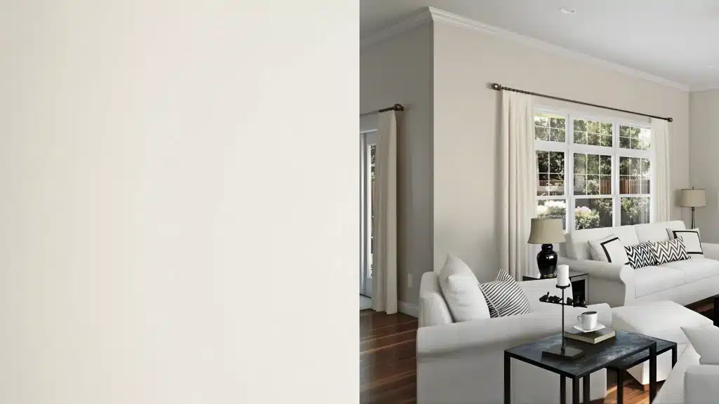 Neutral living room with soft beige walls, white sofas, large window, and natural light creating a calm space